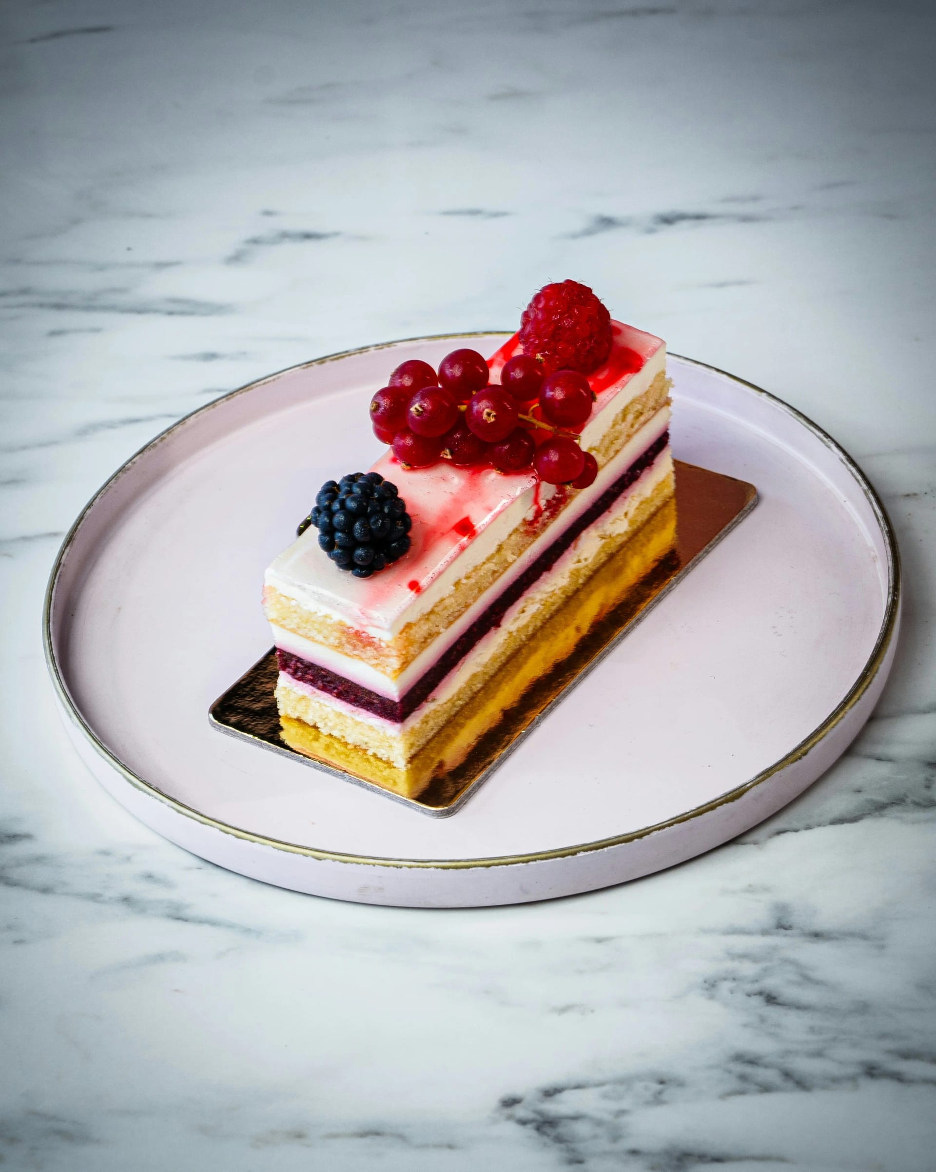 Elegant layered cake decorated with freeze-dried raspberries in a commercial bakery
